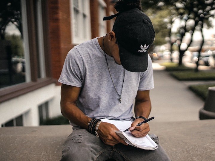 Photo of man writing on the street